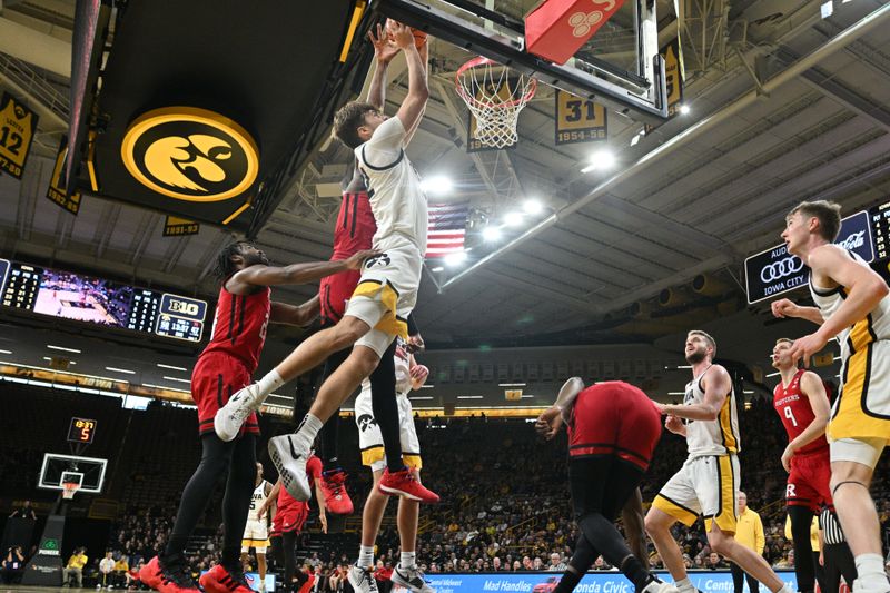 Jan 6, 2024; Iowa City, Iowa, USA; Iowa Hawkeyes forward Owen Freeman (32) goes to the basket as Rutgers Scarlet Knights guard Austin Williams (24) and forward Aundre Hyatt (5) defend during the second half at Carver-Hawkeye Arena. Mandatory Credit: Jeffrey Becker-USA TODAY Sports