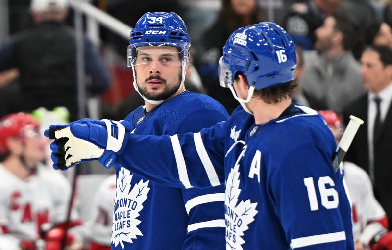 Dec 30, 2023; Toronto, Ontario, CAN; Toronto Maple Leafs forward Mitchell Marner (16) gestures as he speaks with forward Auston Matthews (34) in the first period against the Carolina Hurricanes at Scotiabank Arena. Mandatory Credit: Dan Hamilton-USA TODAY Sports