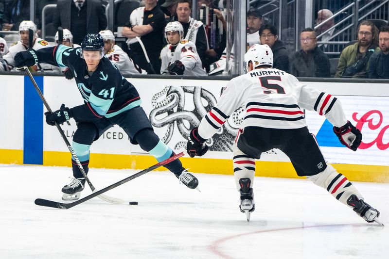 Nov 14, 2024; Seattle, Washington, USA;  Seattle Kraken defenseman Ryker Evans (41) skates against Chicago Blackhawks defenseman Connor Murphy (5) during the first period at Climate Pledge Arena. Mandatory Credit: Stephen Brashear-Imagn Images