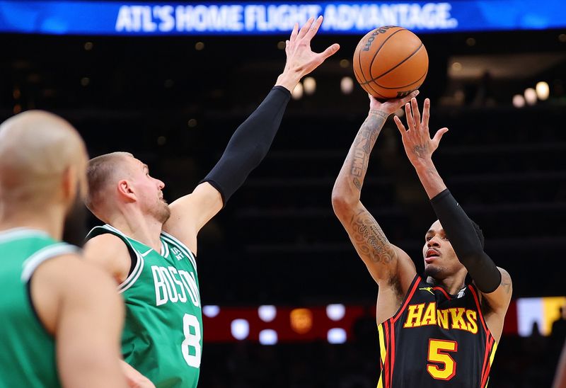 ATLANTA, GEORGIA - MARCH 28:  Dejounte Murray #5 of the Atlanta Hawks shoots a basket against Kristaps Porzingis #8 of the Boston Celtics during overtime at State Farm Arena on March 28, 2024 in Atlanta, Georgia.  NOTE TO USER: User expressly acknowledges and agrees that, by downloading and/or using this photograph, user is consenting to the terms and conditions of the Getty Images License Agreement.  (Photo by Kevin C. Cox/Getty Images)