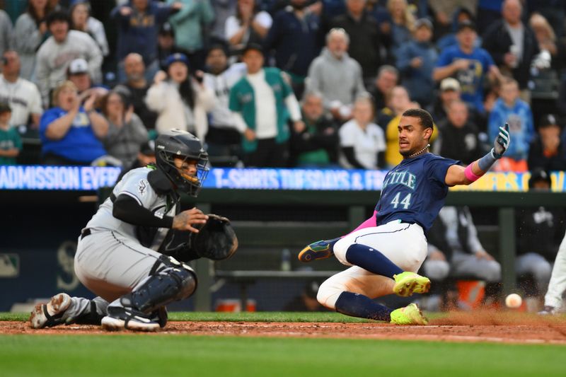 Jun 11, 2024; Seattle, Washington, USA; Seattle Mariners center fielder Julio Rodriguez (44) beats the throw to home plate to score a run against the Chicago White Sox during the seventh inning at T-Mobile Park. Mandatory Credit: Steven Bisig-USA TODAY Sports