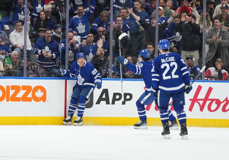 Apr 13, 2024; Toronto, Ontario, CAN; Toronto Maple Leafs left wing Nicholas Robertson (89) scores a goal and celebrates with left wing Matthew Knies (23) against the Detroit Red Wings during the second period at Scotiabank Arena. Mandatory Credit: Nick Turchiaro-USA TODAY Sports