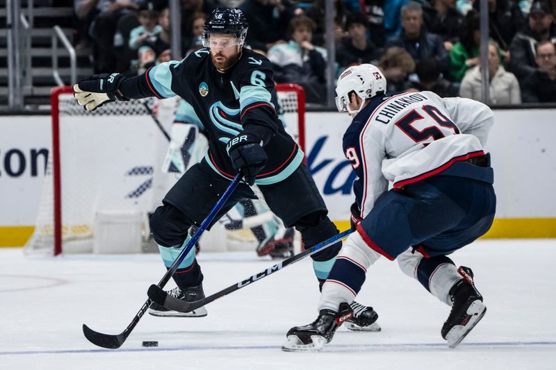 Jan 28, 2024; Seattle, Washington, USA; Seattle Kraken defenseman Adam Larsson (6) attempts to knock the puck away from Columbus Blue Jackets forward Yegor Chinakhov (59) during the second period at Climate Pledge Arena. Mandatory Credit: Stephen Brashear-USA TODAY Sports