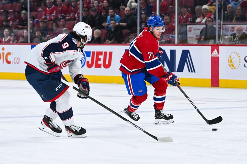 Mar 12, 2024; Montreal, Quebec, CAN; Montreal Canadiens center Jake Evans (71) plays the puck against Columbus Blue Jackets defenseman Ivan Provorov (9) during the first period at Bell Centre. Mandatory Credit: David Kirouac-USA TODAY Sports