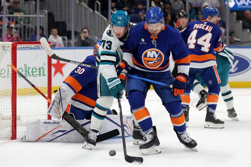 Oct 21, 2025; Elmont, New York, USA; San Jose Sharks center Tyler Toffoli (73) fights for the puck against New York Islanders defenseman Ryan Pulock (6) during the first period at UBS Arena. Mandatory Credit: Brad Penner-Imagn Images