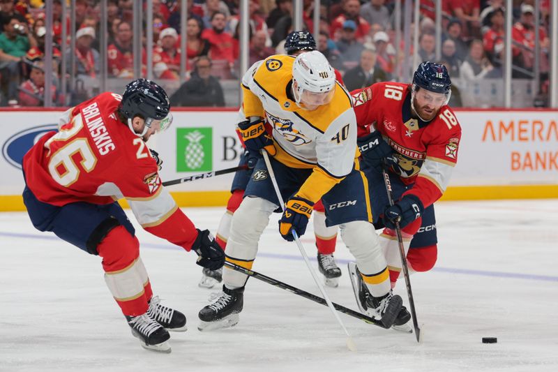 Dec 4, 2025; Sunrise, Florida, USA; Nashville Predators center Fedor Svechkov (40) moves the puck against Florida Panthers left wing Noah Gregor (18) and defenseman Uvis Balinskis (26) during the third period at Amerant Bank Arena. Mandatory Credit: Sam Navarro-Imagn Images