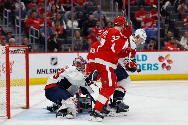 Apr 9, 2024; Detroit, Michigan, USA;  Detroit Red Wings left wing J.T. Compher (37) and Washington Capitals defenseman John Carlson (74) battle for the puck in the second period in front of goaltender Charlie Lindgren (79) at Little Caesars Arena. Mandatory Credit: Rick Osentoski-USA TODAY Sports