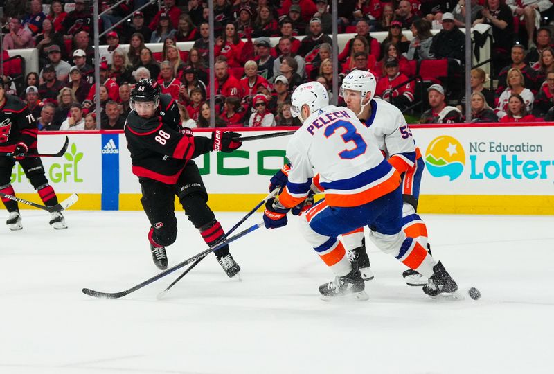 Apr 20, 2024; Raleigh, North Carolina, USA; Carolina Hurricanes center Martin Necas (88) takes a shot past New York Islanders defenseman Adam Pelech (3) during the first period in game one of the first round of the 2024 Stanley Cup Playoffs at PNC Arena. Mandatory Credit: James Guillory-USA TODAY Sports