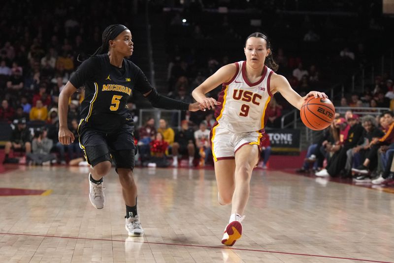 Dec 29, 2024; Los Angeles, California, USA; Southern California Trojans guard Kayleigh Heckel (9) dribbles the ball against Michigan Wolverines guard Brooke Daniels (5) in the first half at Galen Center. Mandatory Credit: Kirby Lee-Imagn Images