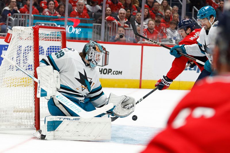 Dec 3, 2024; Washington, District of Columbia, USA; Washington Capitals center Connor McMichael (24) attempts to deflect the puck on San Jose Sharks goaltender Mackenzie Blackwood (29) in the third period at Capital One Arena. Mandatory Credit: Geoff Burke-Imagn Images