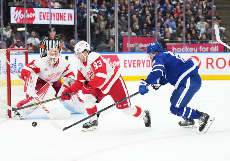 Apr 13, 2024; Toronto, Ontario, CAN; Detroit Red Wings right wing Alex DeBrincat (93) battles for the puck with Toronto Maple Leafs right wing Mitch Marner (16) during the first period at Scotiabank Arena. Mandatory Credit: Nick Turchiaro-USA TODAY Sports