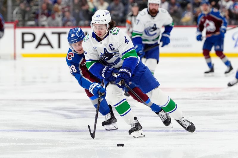 Dec 2, 2025; Denver, Colorado, USA; Colorado Avalanche center Martin Necas (88) defends on Vancouver Canucks defenseman Quinn Hughes (43) during the second period at Ball Arena. Mandatory Credit: Ron Chenoy-Imagn Images