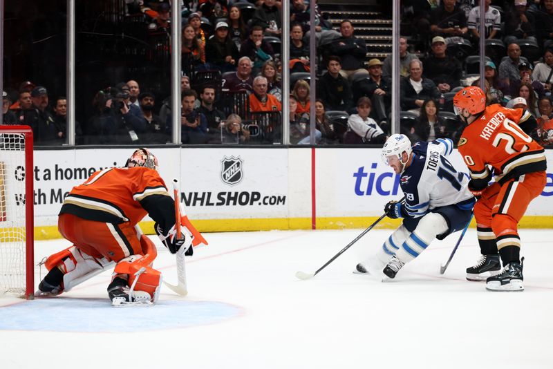 Feb 27, 2026; Anaheim, California, USA;  Winnipeg Jets center Jonathan Toews (19) attacks the goal against Anaheim Ducks goaltender Lukas Dostal (1) during overtime at Honda Center. Mandatory Credit: Kiyoshi Mio-Imagn Images