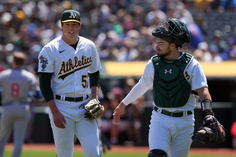 Apr 19, 2023; Oakland, California, USA; Oakland Athletics starting pitcher Mason Miller (left) walks off the field with catcher Shea Langeliers (right) after the top of the first inning against the Chicago Cubs at Oakland-Alameda County Coliseum. Mandatory Credit: Darren Yamashita-USA TODAY Sports