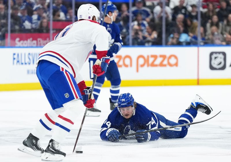 Oct 8, 2025; Toronto, Ontario, CAN; Toronto Maple Leafs center Bobby McMann (74) battles for the puck with Montreal Canadiens defenseman Kaiden Guhle (21) during the first period at Scotiabank Arena. Mandatory Credit: Nick Turchiaro-Imagn Images