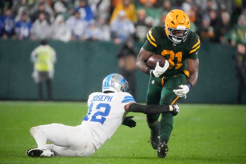 Green Bay Packers running back Emanuel Wilson (31) runs past Detroit Lions safety Brandon Joseph (12) during the second half of an NFL football game Sunday, Nov. 3, 2024, in Green Bay, Wis. (AP Photo/Morry Gash)