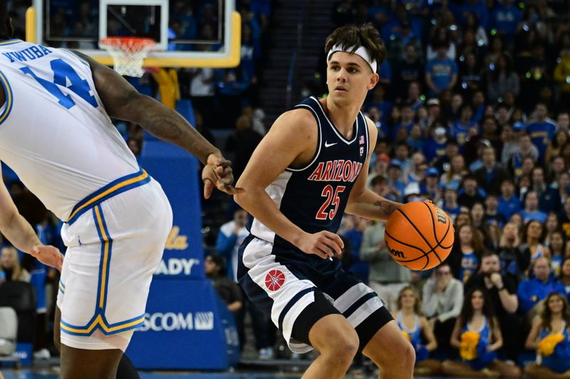 Mar 4, 2023; Los Angeles, California, USA;  Arizona Wildcats guard Kerr Kriisa (25) handles the ball as UCLA Bruins forward Kenneth Nwuba (14) defends during the first half at Pauley Pavilion presented by Wescom. Mandatory Credit: Richard Mackson-USA TODAY Sports