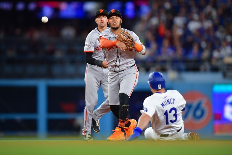 Apr 3, 2024; Los Angeles, California, USA; Los Angeles Dodgers third baseman Max Muncy (13) is out at second as San Francisco Giants second baseman Thairo Estrada (39) throws to first for the out against center fielder Enrique Hernandez (8) during the eighth inning at Dodger Stadium. Mandatory Credit: Gary A. Vasquez-USA TODAY Sports