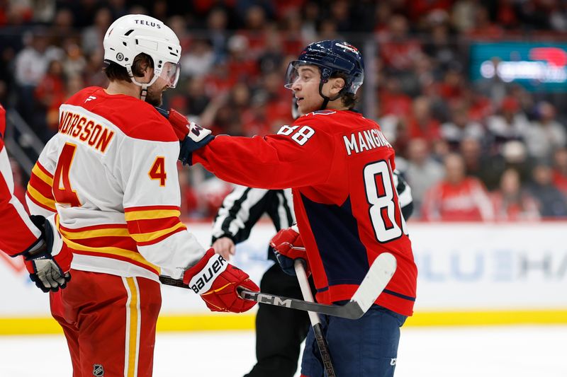 Feb 25, 2025; Washington, District of Columbia, USA; Washington Capitals left wing Andrew Mangiapane (88) grabs Calgary Flames defenseman Rasmus Andersson (4) after a whistle in the third period at Capital One Arena. Mandatory Credit: Geoff Burke-Imagn Images