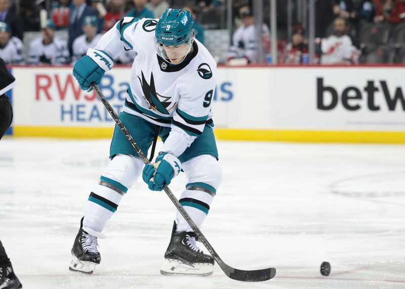 Dec 1, 2023; Newark, New Jersey, USA; San Jose Sharks defenseman Jacob MacDonald (9) deflects the puck for a goal during the second period against the New Jersey Devils at Prudential Center. Mandatory Credit: Vincent Carchietta-USA TODAY Sports