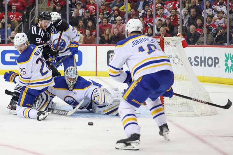 Oct 27, 2023; Newark, New Jersey, USA; Buffalo Sabres goaltender Ukko-Pekka Luukkonen (1) reaches for the puck between defenseman Rasmus Dahlin (26) and defenseman Henri Jokiharju (10) during the third period in front of New Jersey Devils center Dawson Mercer (91) at Prudential Center. Mandatory Credit: Vincent Carchietta-USA TODAY Sports