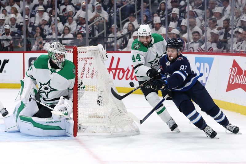 May 9, 2025; Winnipeg, Manitoba, CAN;Dallas Stars defenseman Cody Ceci (44) and Winnipeg Jets center Cole Perfetti (91) eye a bouncing puck beside Dallas Stars goaltender Jake Oettinger (29) in the second period in game two of the second round of the 2025 Stanley Cup Playoffs at Canada Life Centre. Mandatory Credit: James Carey Lauder-Imagn Images