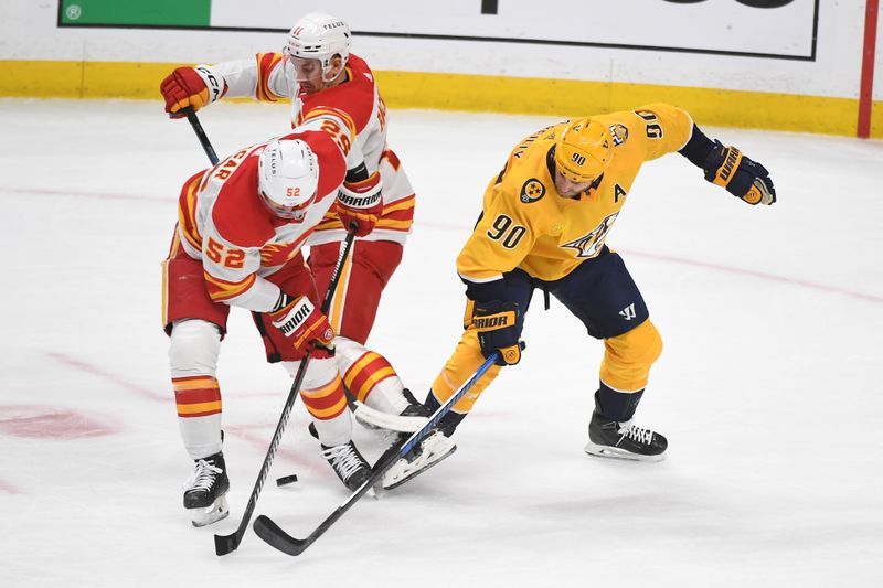 Jan 4, 2024; Nashville, Tennessee, USA; Nashville Predators center Ryan O'Reilly (90) takes the puck from Calgary Flames defenseman MacKenzie Weegar (52) and center Mikael Backlund (11) during the first period at Bridgestone Arena. Mandatory Credit: Christopher Hanewinckel-USA TODAY Sports