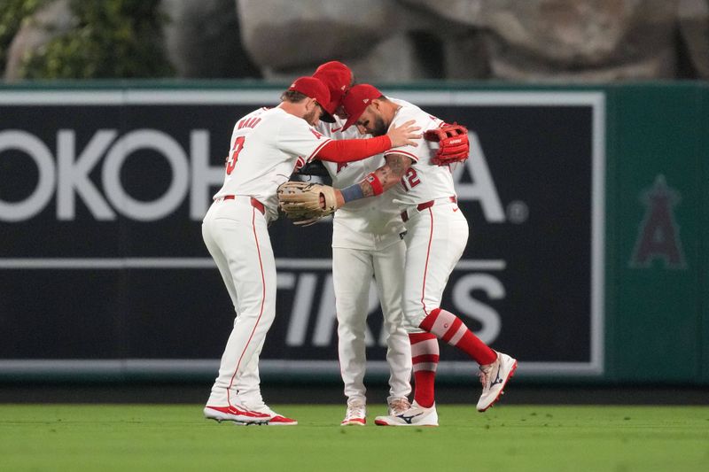 Jul 10, 2024; Anaheim, California, USA; Los Angeles Angels left fielder Taylor Ward (3), center fielder Mickey Moniak (16) and right fielder Kevin Pillar (12) celebrate after a game against the Texas Rangers at Angel Stadium. Mandatory Credit: Kirby Lee-USA TODAY Sports