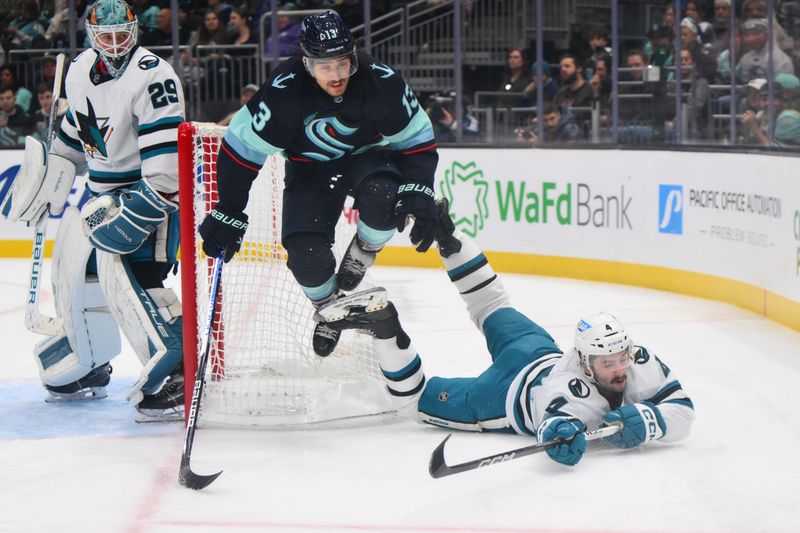 Nov 22, 2023; Seattle, Washington, USA; Seattle Kraken left wing Brandon Tanev (13) jumps over San Jose Sharks defenseman Kyle Burroughs (4) during the second period at Climate Pledge Arena. Mandatory Credit: Steven Bisig-USA TODAY Sports