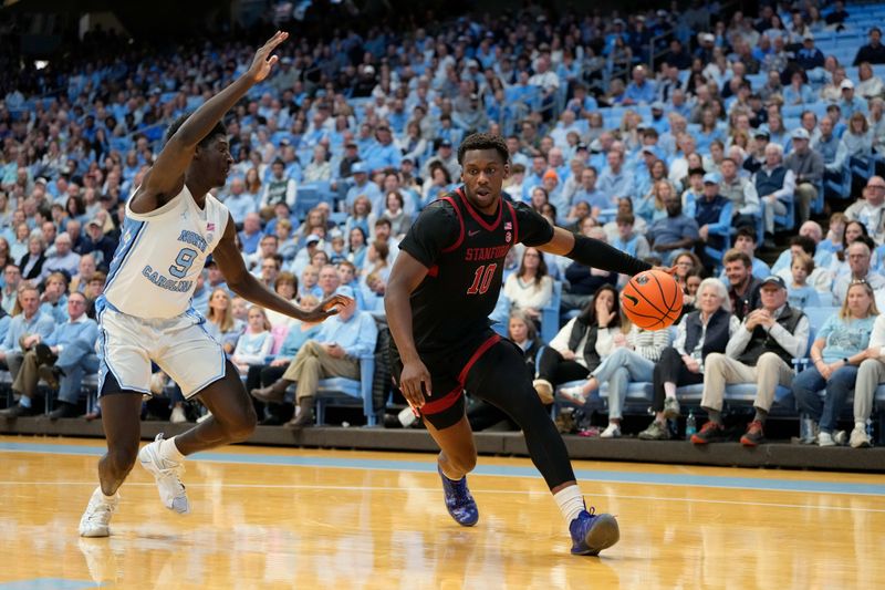 Jan 18, 2025; Chapel Hill, North Carolina, USA; Stanford Cardinal forward Chisom Okpara (10) dribbles as North Carolina Tar Heels guard Drake Powell (9) defends in the first half at Dean E. Smith Center. Mandatory Credit: Bob Donnan-Imagn Images