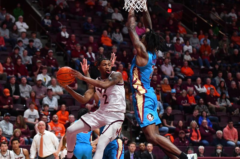 Feb 13, 2024; Blacksburg, Virginia, USA;  Virginia Tech Hokies guard MJ Collins (2) looks to pass the ball while being defended by Florida State Seminoles forward Jamir Watkins (2) during the second half at Cassell Coliseum. Mandatory Credit: Brian Bishop-USA TODAY Sports