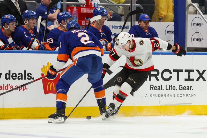 Mar 16, 2024; Elmont, New York, USA;  Ottawa Senators left wing Parker Kelly (27) looks to control the puck while New York Islanders defenseman Mike Reilly (2) defends during the first period at UBS Arena. Mandatory Credit: Thomas Salus-USA TODAY Sports