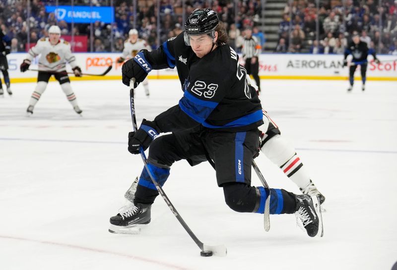 Dec 2, 2024; Toronto, Ontario, CAN; Toronto Maple Leafs forward Matthew Knies (23) scores an empty net goal against the Chicago Blackhawks on this shot during the third period at Scotiabank Arena. Mandatory Credit: John E. Sokolowski-Imagn Images