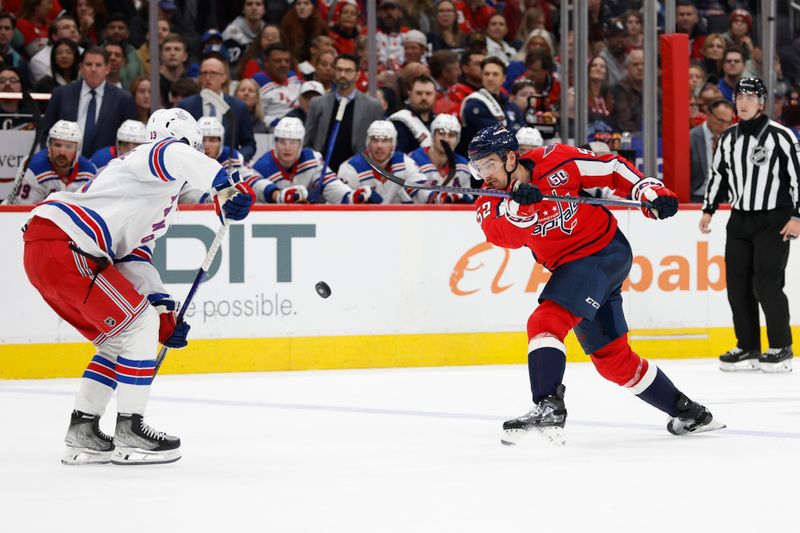 Oct 29, 2024; Washington, District of Columbia, USA; Washington Capitals defenseman Dylan McIlrath (52) shoots the puck as New York Rangers left wing Alexis Lafrenière (13) defends in the third period at Capital One Arena. Mandatory Credit: Geoff Burke-Imagn Images