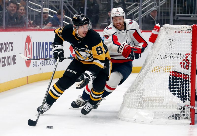 Jan 2, 2024; Pittsburgh, Pennsylvania, USA;  Pittsburgh Penguins center Sidney Crosby (87) moves the puck behind the net as Washington Capitals defenseman Nick Jensen (3) chases during the first period at PPG Paints Arena. Mandatory Credit: Charles LeClaire-USA TODAY Sports