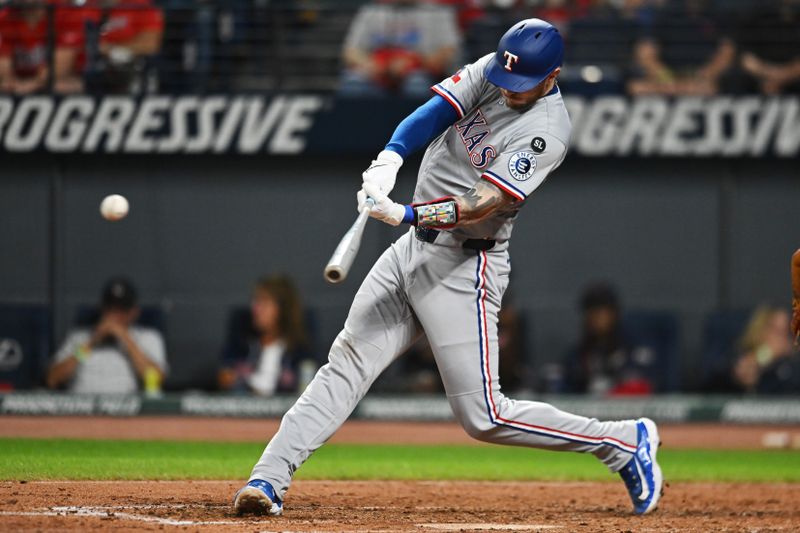 Sep 26, 2025; Cleveland, Ohio, USA; Texas Rangers catcher Jonah Heim (28) hits a single against the Cleveland Guardians during the fourth inning at Progressive Field. Mandatory Credit: Ken Blaze-Imagn Images
