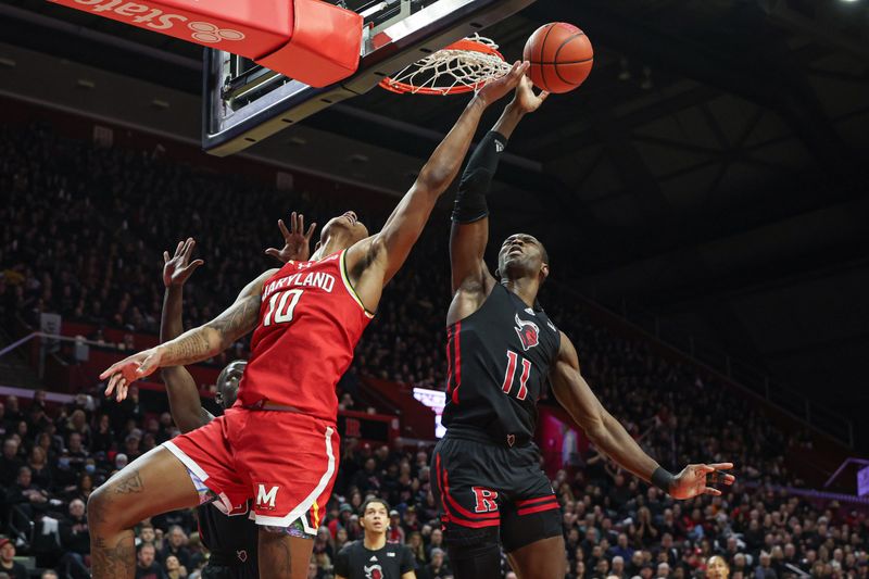 Feb 25, 2024; Piscataway, New Jersey, USA; Rutgers Scarlet Knights center Clifford Omoruyi (11) blocks a shot by Maryland Terrapins forward Julian Reese (10) during the first half at Jersey Mike's Arena. Mandatory Credit: Vincent Carchietta-USA TODAY Sports