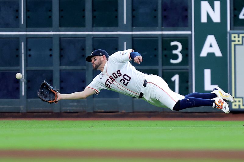 Jul 13, 2024; Houston, Texas, USA; Houston Astros left fielder Chas McCormick (20) dives to catch a fly ball for an out against the Texas Rangers during the fourth inning at Minute Maid Park. Mandatory Credit: Erik Williams-USA TODAY Sports