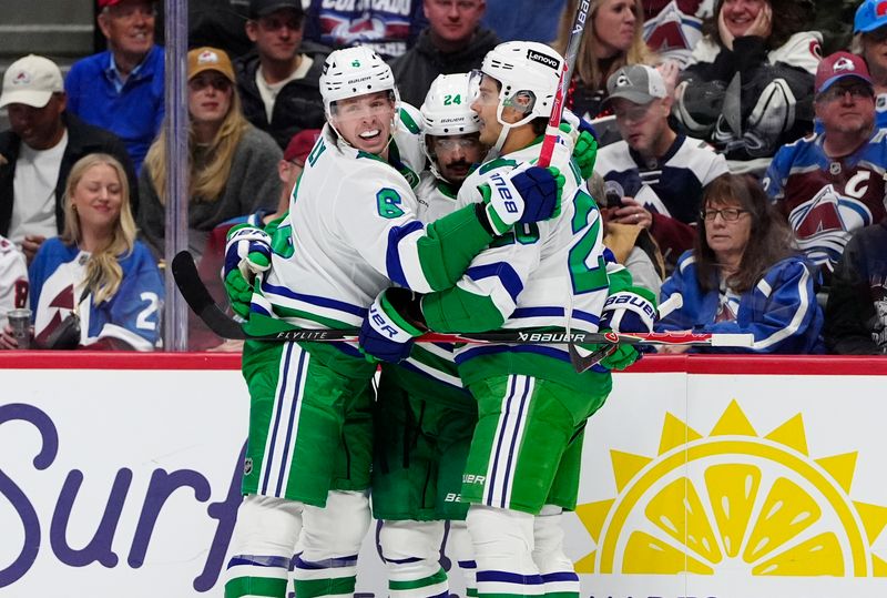 Oct 23, 2025; Denver, Colorado, USA; Carolina Hurricanes center Seth Jarvis (24) celebrates his goal with defenseman Mike Reilly (6) and center Sebastian Aho (20) in the first period against the Colorado Avalanche at Ball Arena. Mandatory Credit: Ron Chenoy-Imagn Images