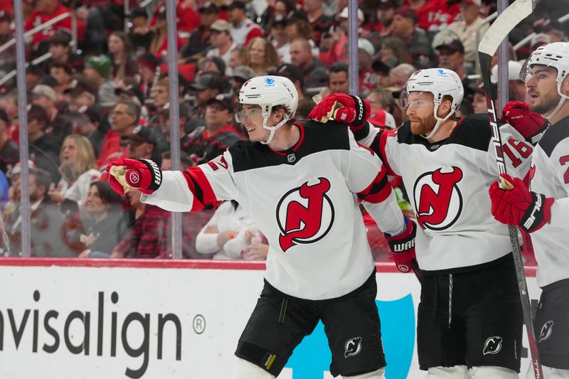 Oct 9, 2025; Raleigh, North Carolina, USA;  New Jersey Devils center Cody Glass (12) celebrates his goal with right wing Connor Brown (16) against the Carolina Hurricanes during the second period at Lenovo Center. Mandatory Credit: James Guillory-Imagn Images