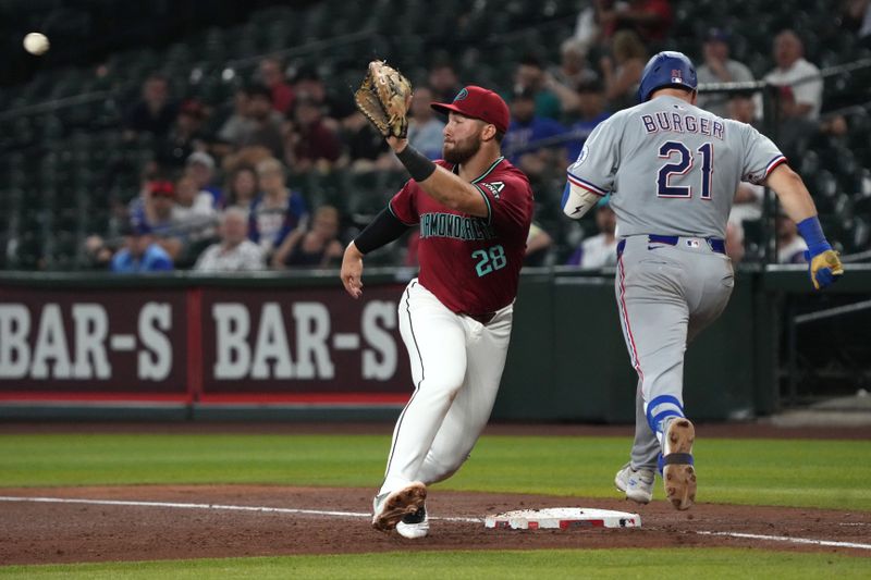 Sep 3, 2025; Phoenix, Arizona, USA; Arizona Diamondbacks first base Tyler Locklear (28) tries to tag out Texas Rangers first base Jake Burger (21) in the sixth inning at Chase Field. Mandatory Credit: Rick Scuteri-Imagn Images