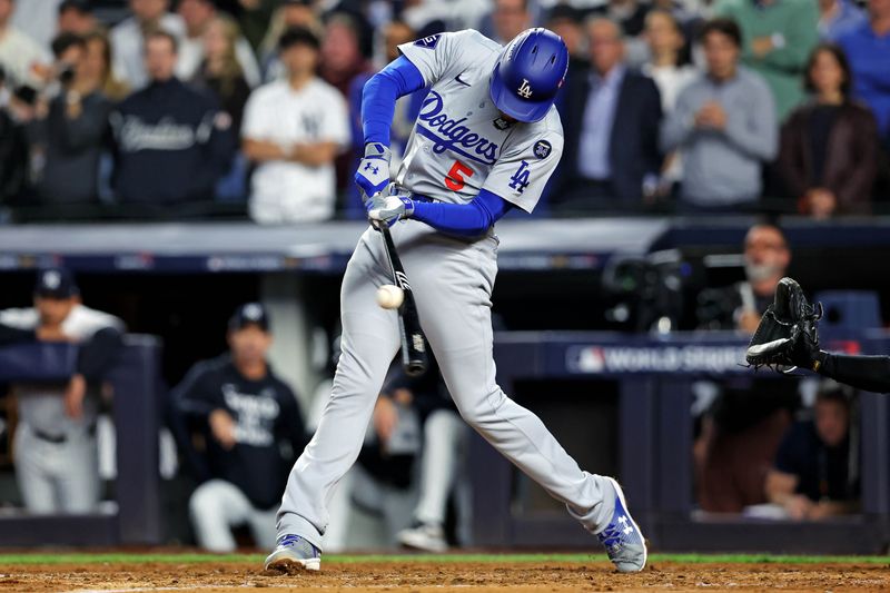 Oct 30, 2024; New York, New York, USA; Los Angeles Dodgers first baseman Freddie Freeman (5) hits a two RBI single during the fifth inning against the New York Yankees in game four of the 2024 MLB World Series at Yankee Stadium. Mandatory Credit: Brad Penner-Imagn Images