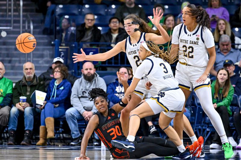 Jan 14, 2024; South Bend, Indiana, USA; Miami Hurricanes guard Shayeann Day-Wilson (30) loses the ball as Notre Dame Fighting Irish forward Maddy Westbeld (21) and guard Hannah Hidalgo (3) defend in the first half at the Purcell Pavilion. Mandatory Credit: Matt Cashore-USA TODAY Sports