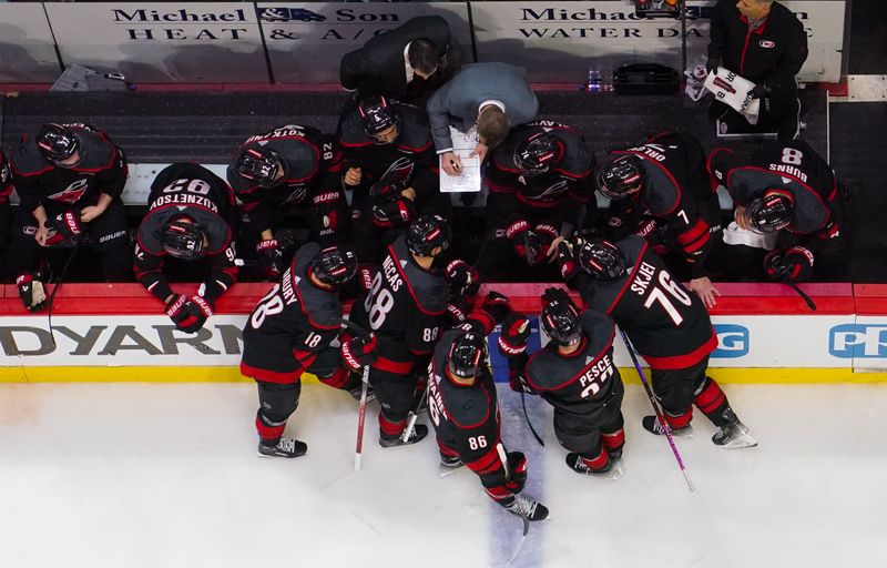 Apr 20, 2024; Raleigh, North Carolina, USA; Carolina Hurricanes head coach Road Brind’Amour and assistant coach Tim Gleason talk to their players against the New York Islanders during the third period in game one of the first round of the 2024 Stanley Cup Playoffs at PNC Arena. Mandatory Credit: James Guillory-USA TODAY Sports