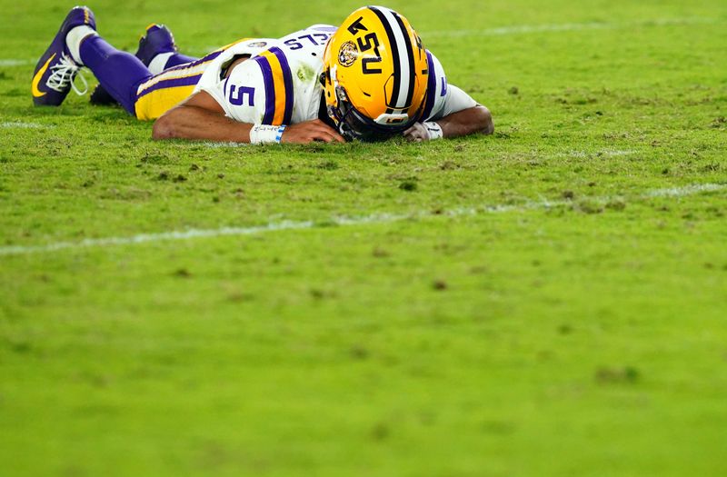 Nov 4, 2023; Tuscaloosa, Alabama, USA; LSU Tigers quarterback Jayden Daniels (5) lays on the ground after being hit by the Alabama Crimson Tide defense during the second half at Bryant-Denny Stadium. After review Alabama was penalized with roughing the passer. Mandatory Credit: John David Mercer-USA TODAY Sports