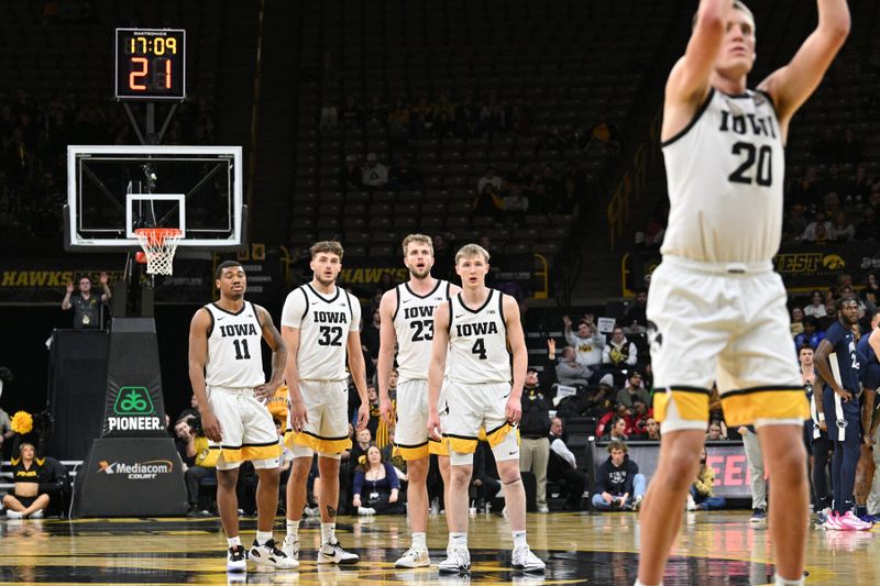 Feb 27, 2024; Iowa City, Iowa, USA; Iowa Hawkeyes guard Tony Perkins (11) and forward Owen Freeman (32) and forward Ben Krikke (23) and guard Josh Dix (4) look on as forward Payton Sandfort (20) shoots a free throw after a technical foul by the Penn State Nittany Lions during the second half at Carver-Hawkeye Arena. Mandatory Credit: Jeffrey Becker-USA TODAY Sports