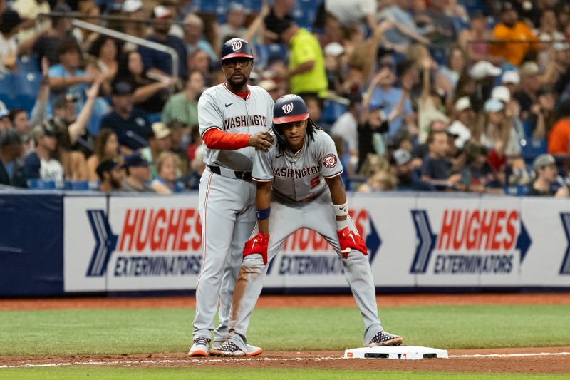 Jun 29, 2024; St. Petersburg, Florida, USA; Washington Nationals third base coach Ricky Gutierrez (12) rubs the shoulders of Washington Nationals shortstop CJ Abrams (5) against the Tampa Bay Rays during the seventh inning at Tropicana Field. Mandatory Credit: Matt Pendleton-USA TODAY Sports