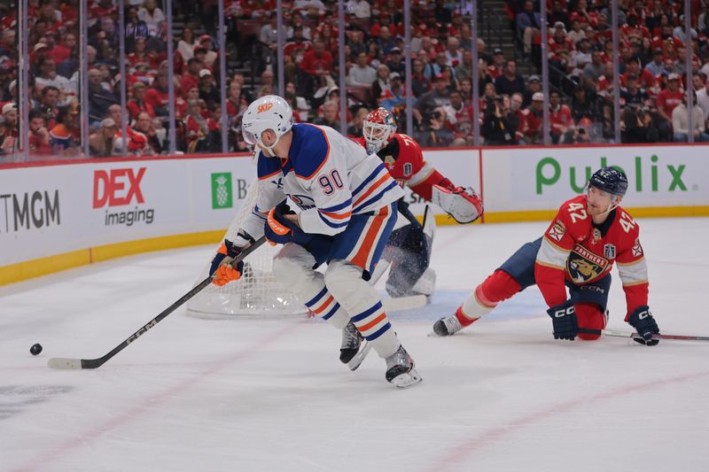 Jun 9, 2025; Sunrise, Florida, USA; Edmonton Oilers right wing Corey Perry (90) reaches for the puck against Florida Panthers defenseman Gustav Forsling (42) during the first period in game three of the 2025 Stanley Cup Final at Amerant Bank Arena. Mandatory Credit: Sam Navarro-Imagn Images