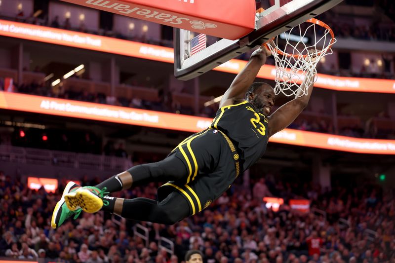 SAN FRANCISCO, CALIFORNIA - FEBRUARY 14: Draymond Green #23 of the Golden State Warriors holds on to the rim after dunking the ball against the LA Clippers in the first half at Chase Center on February 14, 2024 in San Francisco, California. NOTE TO USER: User expressly acknowledges and agrees that, by downloading and or using this photograph, User is consenting to the terms and conditions of the Getty Images License Agreement.  (Photo by Ezra Shaw/Getty Images)