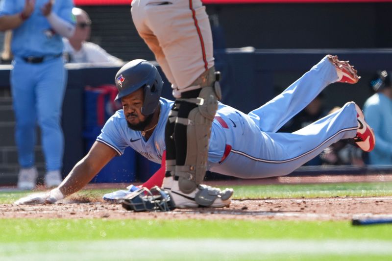 Sep 14, 2025; Toronto, Ontario, CAN; Toronto Blue Jays first base Vladimir Guerrero Jr. (27) slides into home plate to score against the Baltimore Orioles during the seventh inning at Rogers Centre. Mandatory Credit: Kevin Sousa-Imagn Images